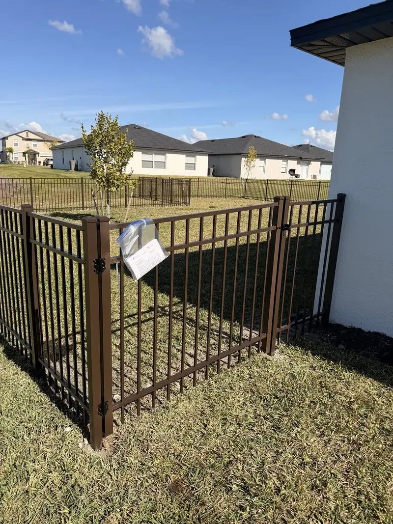 Bronze aluminum picket panels and a walk gate with black hinges were set beside the house to close off the side yard.