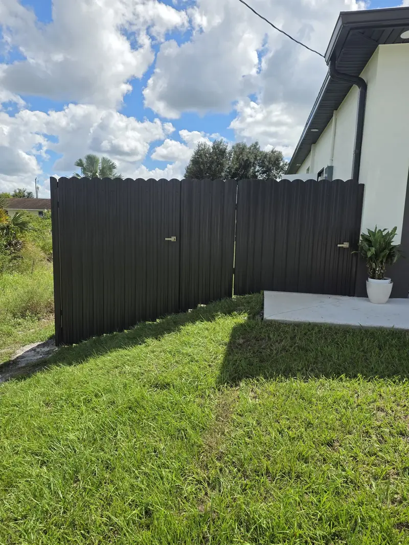 Privacy side gate with matching dark fence panels beside a home in the Monarca project collection