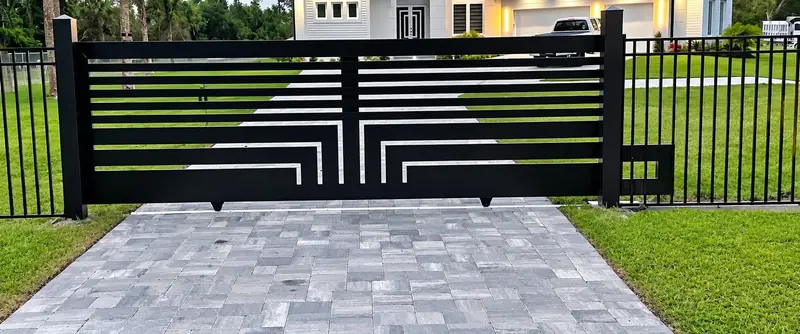 A black driveway gate with horizontal slats and geometric center detailing.